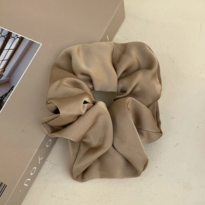 Elegant champagne gold satin scrunchie with a glossy silk finish for classic hairstyling