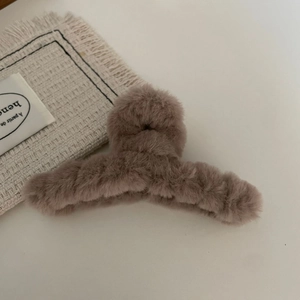 Close-up of plush brown heart claw clip with soft faux fur texture for winter hair styling