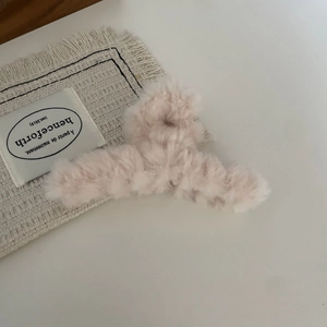 Close-up of soft plush heart hair claw in milk tea pink for elegant winter styling