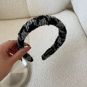 Detail of tweed braided headband showing black and white texture and hand made label