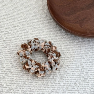 Close-up of soft fuzzy knit hair scrunchie with mixed coffee, beige and blue fibers
