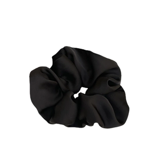 Elegant black satin hair scrunchie with smooth silk texture and layered pleated design