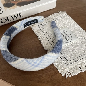 Detail of blue and white plaid padded headband with handcrafted inner label on wood