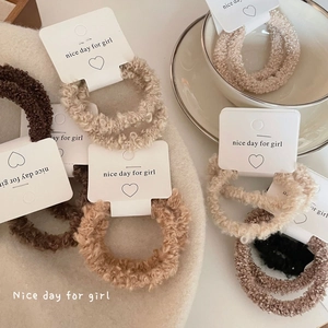 Lambswool hair scrunchies set in earth tones displayed on a decorative paper card