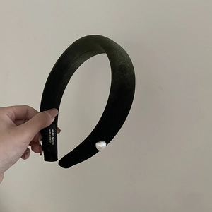 Detail of green velvet padded headband with white pearl and handmade label tag