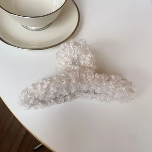 Pince à cheveux blanche en fausse fourrure avec une texture pelucheuse élégante
