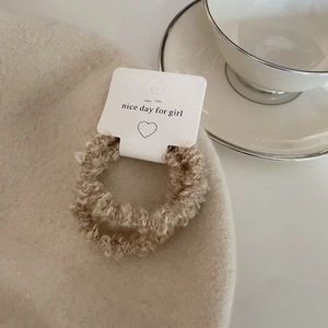 Macro view of plush khaki lamb wool hair scrunchies on a nice day for girl card