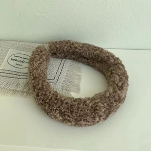 Close-up of thick brown plush headband with soft teddy fleece texture for winter