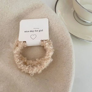 Close-up of soft beige lamb wool scrunchie on nice day for girl branded paper card packaging