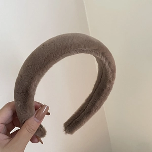 Gros plan du bandeau épais en peluche marron café avec texture douce en fausse fourrure