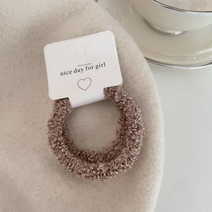 Close-up of soft brown faux shearling scrunchie with warm latte fleece texture