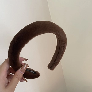 Détail du serre-tête en peluche marron doux avec étiquette faite main et texture moelleuse