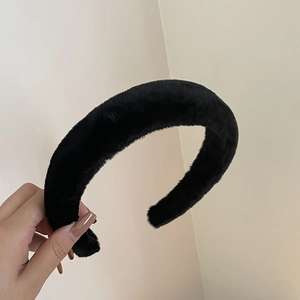 Gros plan du serre-tête en peluche noire épaisse montrant le tissu doux et la qualité