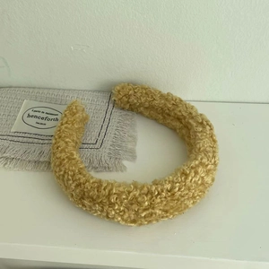 Close-up of warm yellow lamb wool headband showing soft curly teddy fleece texture