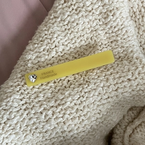 Yellow acetate hair clip with crystal heart on a cozy cream knit background