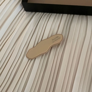 French style wave edge acetate hair clip in matte nude beige on white fabric background