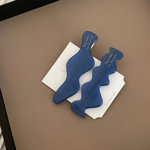 Détail de barrettes à cheveux ondulées bleu marine en acétate avec texte doré
