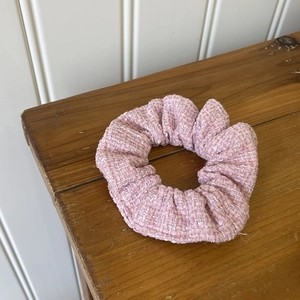 Pink plaid tweed scrunchie hair tie on wooden surface for elegant high bun hair styling