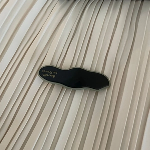 Detail view of wave-shaped black acetate hair clip with Barrette La France gold lettering