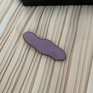 Detailed close-up of a lilac wave-shaped acetate hair clip with brown borders