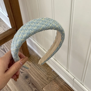 Detailed view of wide sponge padded tweed headband in blue and yellow woven fabric