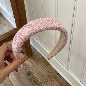 Detail of light pink tweed wide headband showing woven texture and anti-slip lining