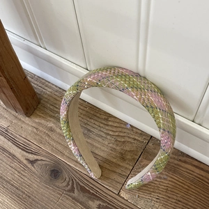 Detailed view of pink and green tweed plaid headband with premium woven texture