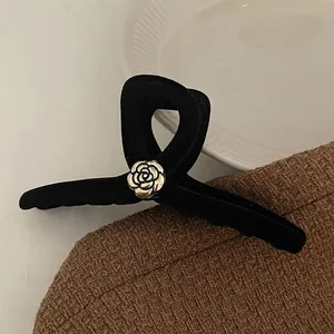 Elegant black velvet hair claw clip with golden camellia floral detail for women