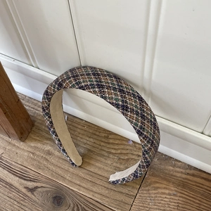 Detail of blue and brown tweed plaid padded headband with soft beige velvet lining