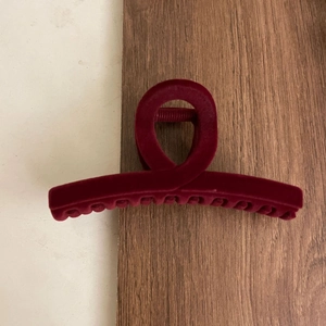 Macro detail of large burgundy flocked hair claw clip with velvet finish and cross design