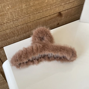 Detail of plush faux rabbit fur shark hair clip in brown with soft texture and internal clip