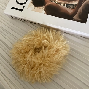 Détail d'un chouchou en fausse fourrure jaune duveteuse avec texture peluche