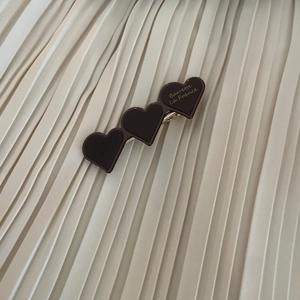 Macro detail of brown heart hair clip with Barrette La France gold engraving text