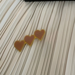 Detail showing three heart-shaped acetate hair clips with Barrette La France text