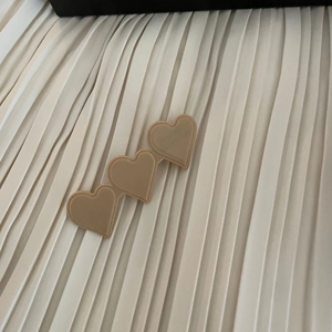 Detailed macro view of heart-shaped acetate hair clip in matte khaki with engraved text