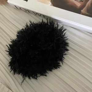 Détail macro d'un chouchou en fausse fourrure noire sur un fond en tissu blanc