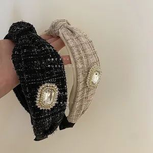 Detail of tweed knotted headbands with large crystal buckle in black and beige colors