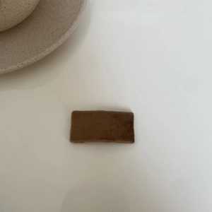 Detail view of a brown velvet hair clip with a soft plush texture for girls