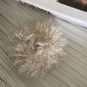 Chouchou en peluche imitation laine beige sur un fond esthétique minimaliste