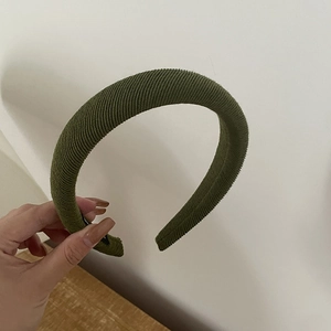 Detailed view of dark green ribbed knit headband with thickened padded sponge design