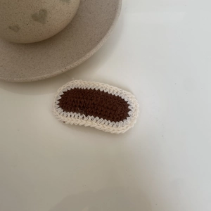 Detailed macro view of the handmade knit hair clip with brown and cream crochet textures