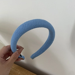 Macro shot of light blue striped knitted fabric headband with thick padded texture