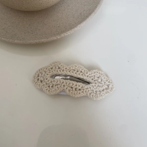 Detail of hand-knitted wave-edge cream hair clip with high-quality crochet texture