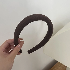 Close-up of brown quilted fabric headband showing diamond pattern and thick padding texture