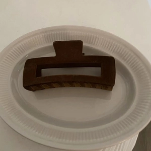 Minimalist dark brown matte rectangular hair claw clip for women displayed on ceramic
