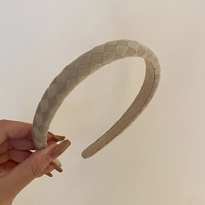 Détail d'un serre-tête beige à motif damier avec doublure antidérapante