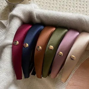 Glossy satin padded headband set with gold metal accents in six elegant colors