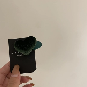 Detail einer dunkelgrünen, beflockten herzförmigen Haarspange auf Displaykarte