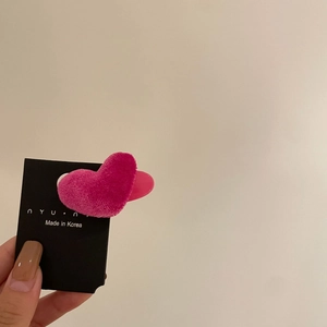 Detail einer beflockten herzförmigen Haarspange in Magentarosa mit Samtstruktur