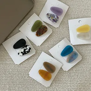 Detail view of colorful acetate teardrop hair clips with marble and tortoise textures